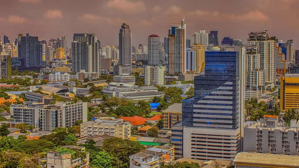 The Bangkok skyline of high-rises and glass towers under a dusky sky
